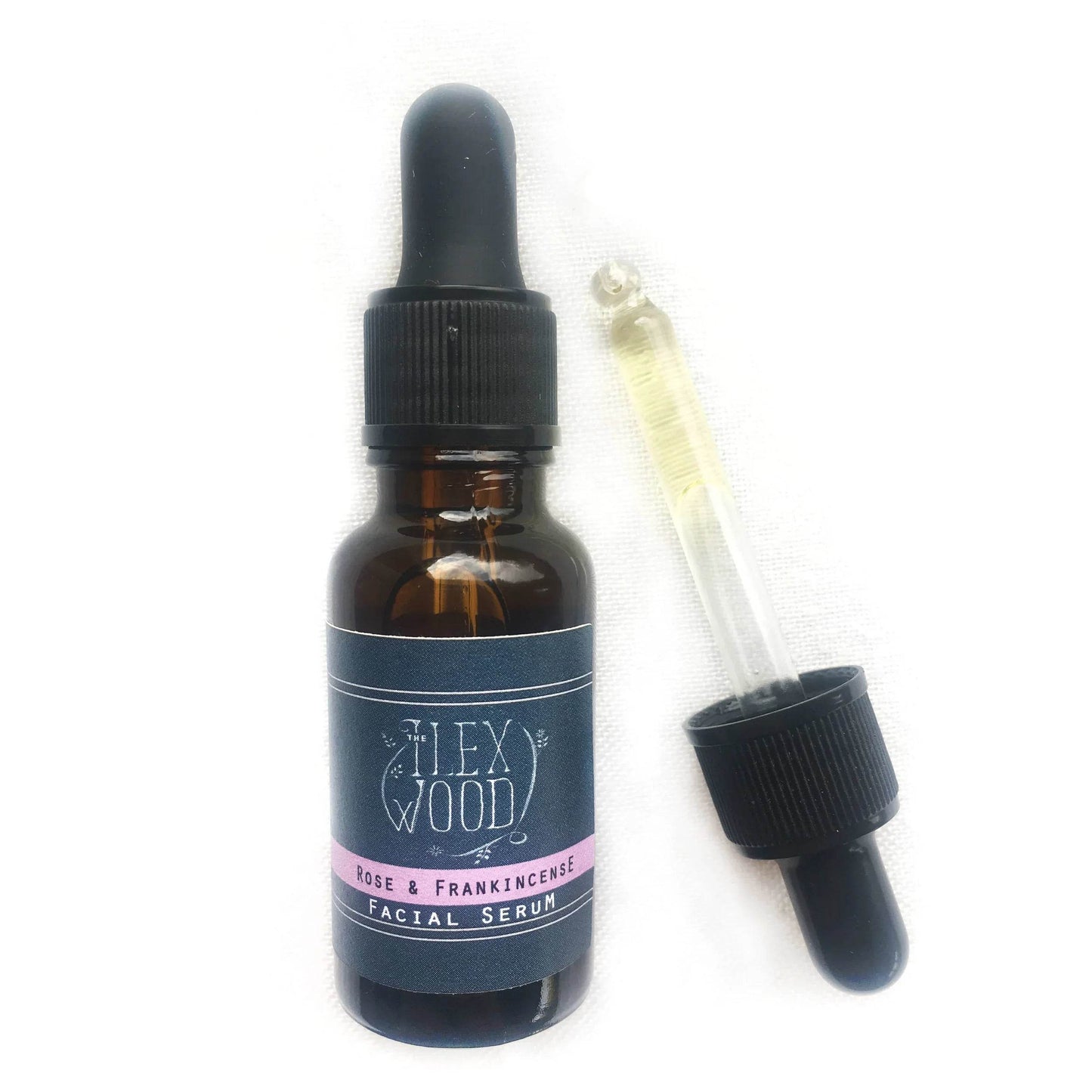 Rose and Frankincense facial serum bottle with dropper on white background