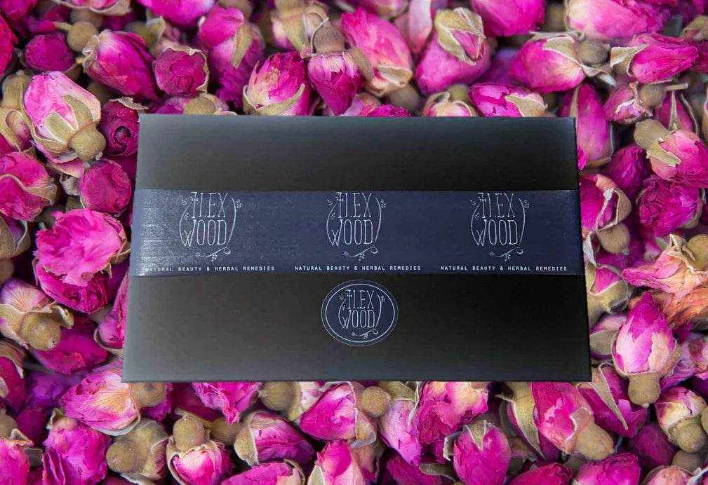 The Ilex Wood natural vegan skin care gift box on bed of pink dried rose buds